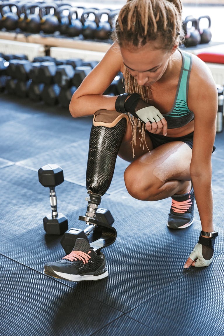 a person with a prosthetic leg is squatting in a gym near the free weights